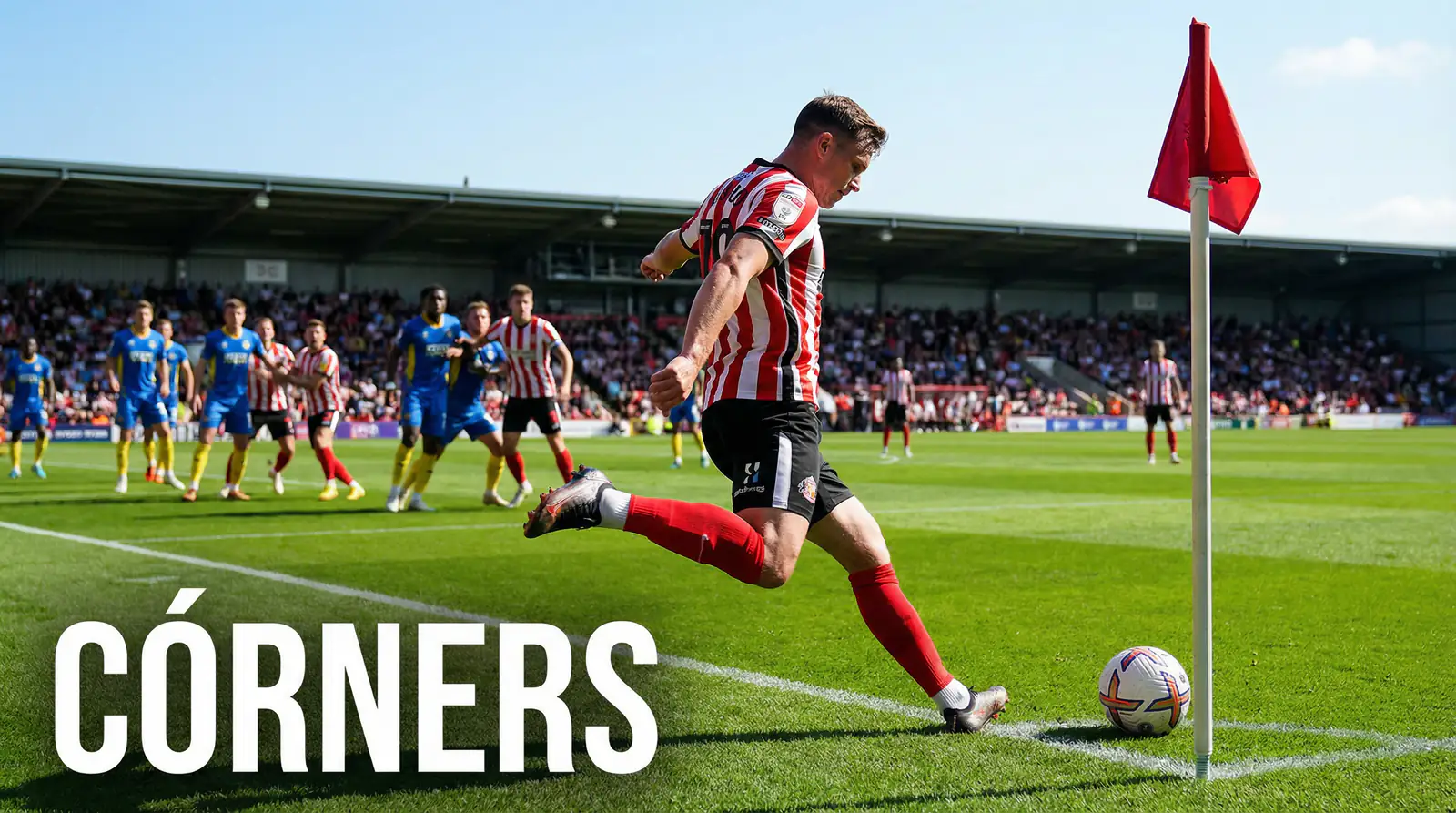 Jugador de fútbol ejecutando un saque de esquina en un estadio profesional con banderín de córner